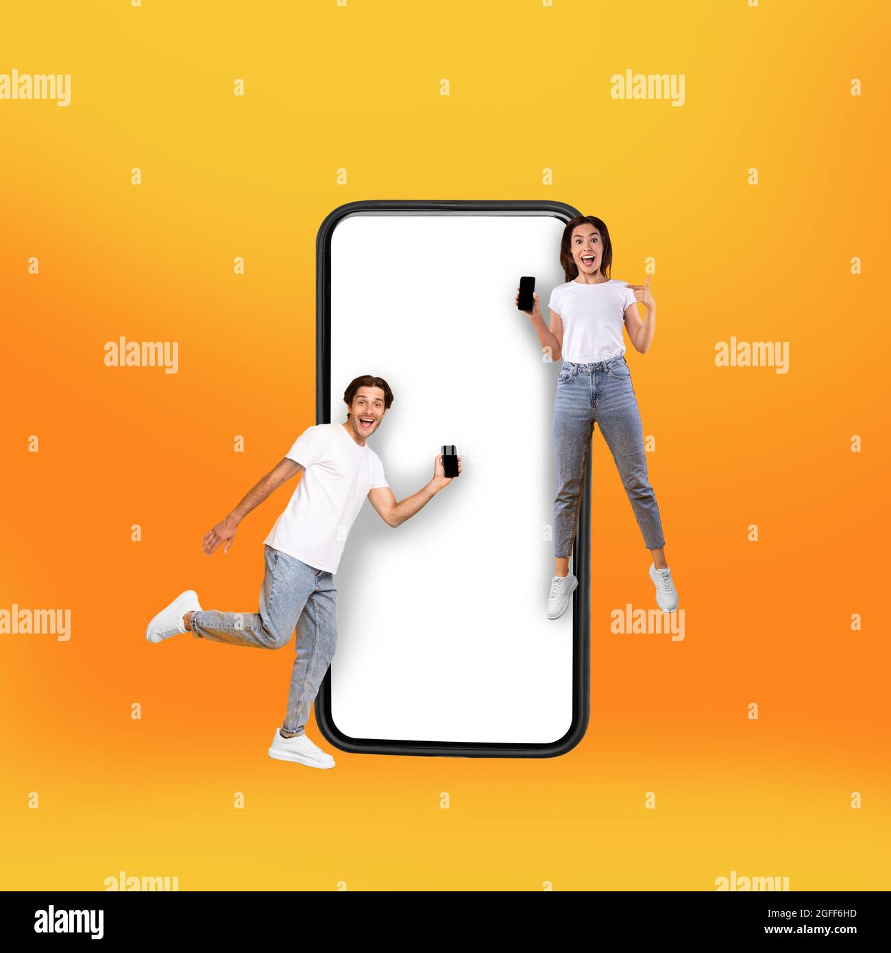 Couple showing white empty smartphone screen and jumping Stock Photo