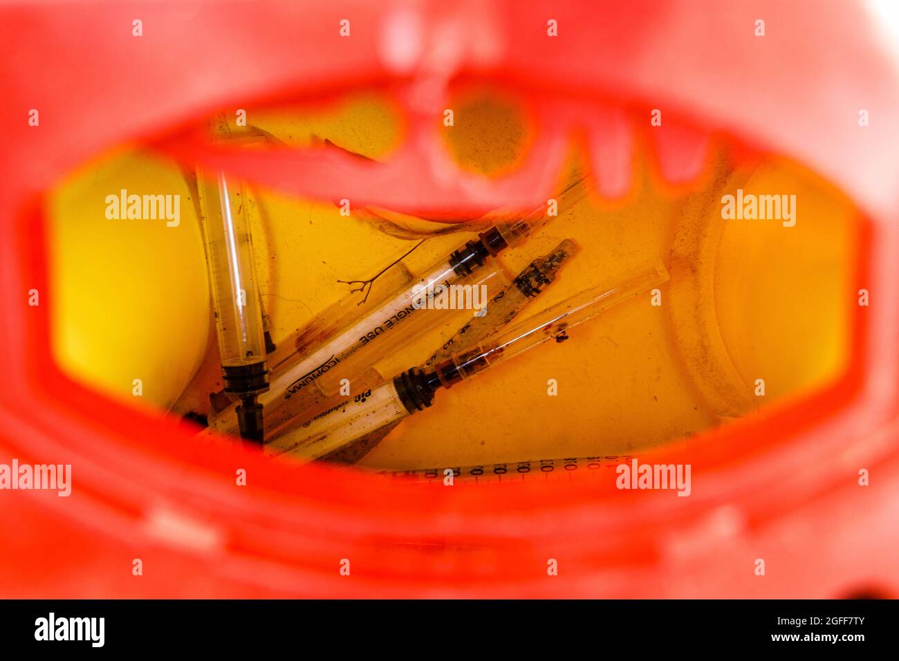 Used Heroin Syringes in Sharps Container Stock Photo