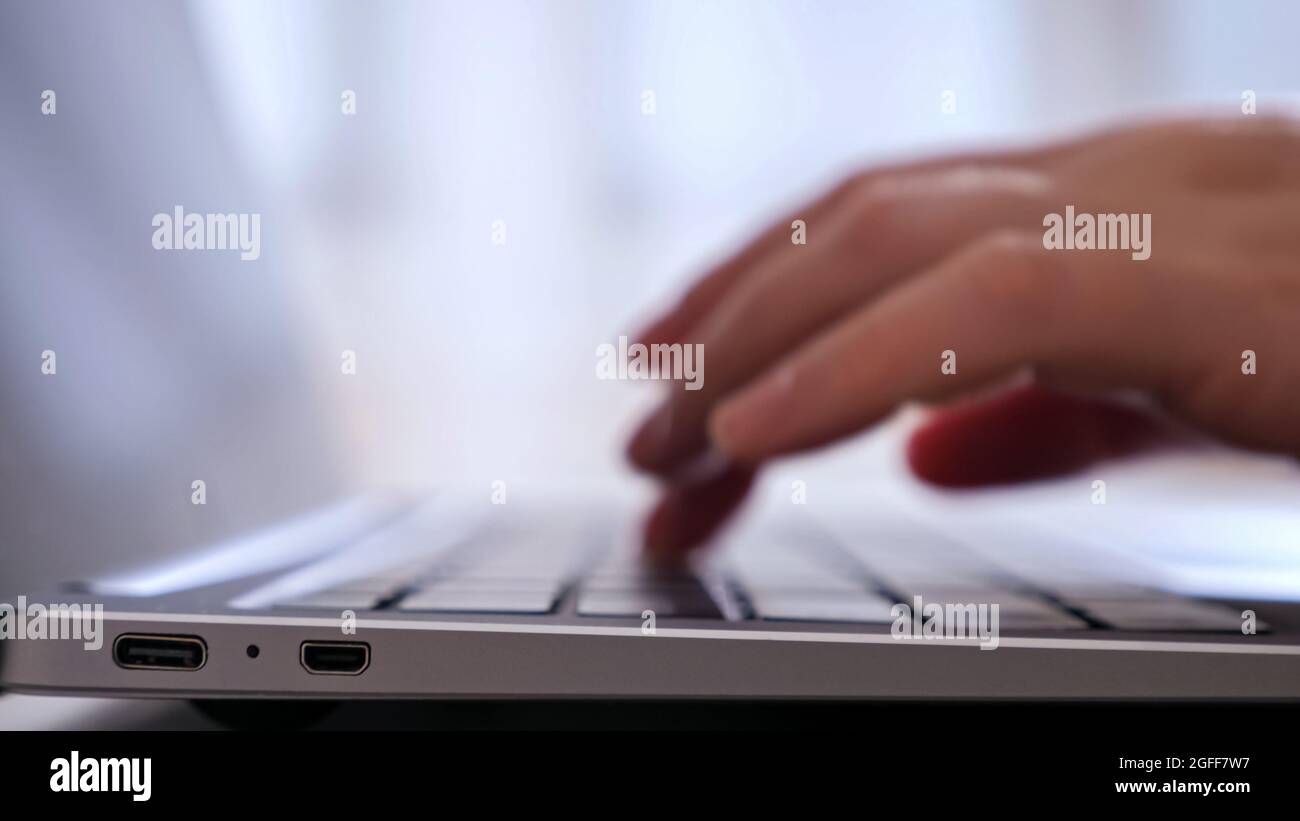 unrecognizable person types on laptop. Stock Photo