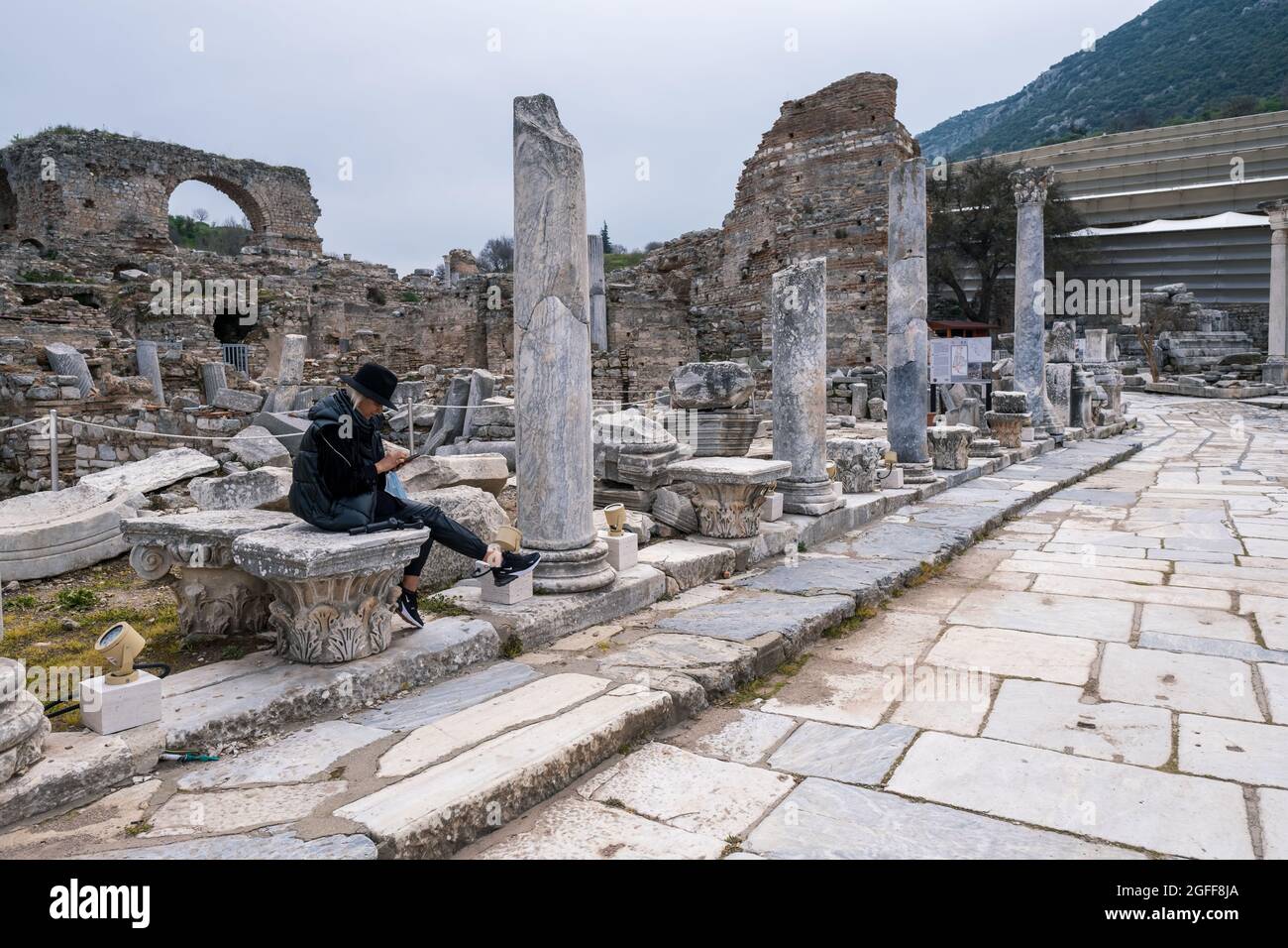 Selcuk, Izmir, Turkey - 03.09.2021: a woman tourist sitting on stones