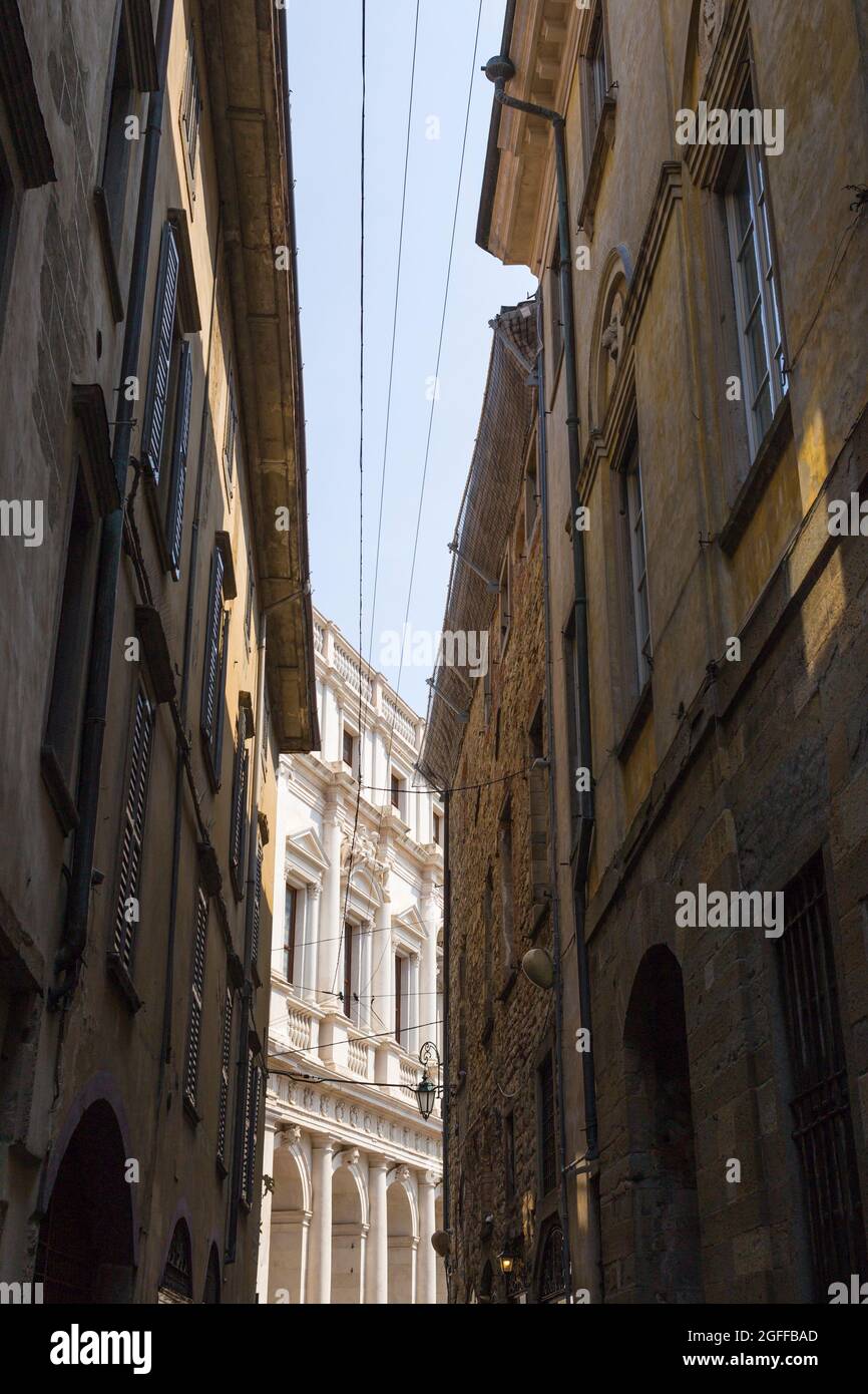 Citta Alta, Bergamo, Italy: typical street scene; narrow, curving street; glimpse of Palazzo Nuovo (Biblioteca Civica Angelo Mai). Stock Photo