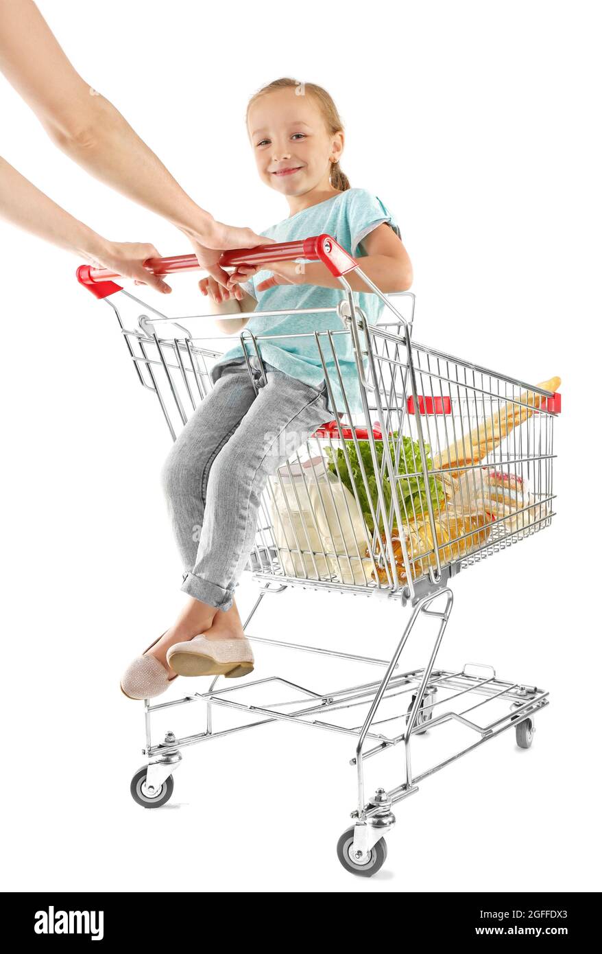 Cute girl sitting in shopping cart with pack of products on white ...