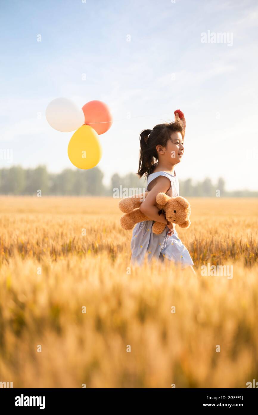 Little girl playing in wheat field Stock Photo - Alamy