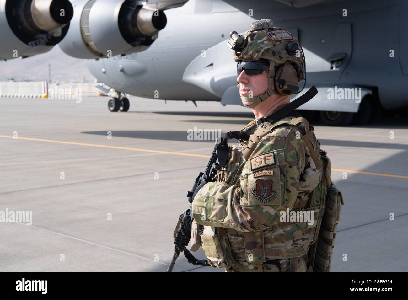 Kabul, Afghanistan. 24th Aug, 2021. A U.S. Air Force airman with security forces raven, 816th Expeditionary Airlift Squadron, maintains a security cordon around a U.S. Air Force C-17 Globemaster III aircraft during the evacuation of Afghan refugees during Operation Allies Refuge August 24, 2021 in Kabul, Afghanistan. Credit: Planetpix/Alamy Live News Stock Photo