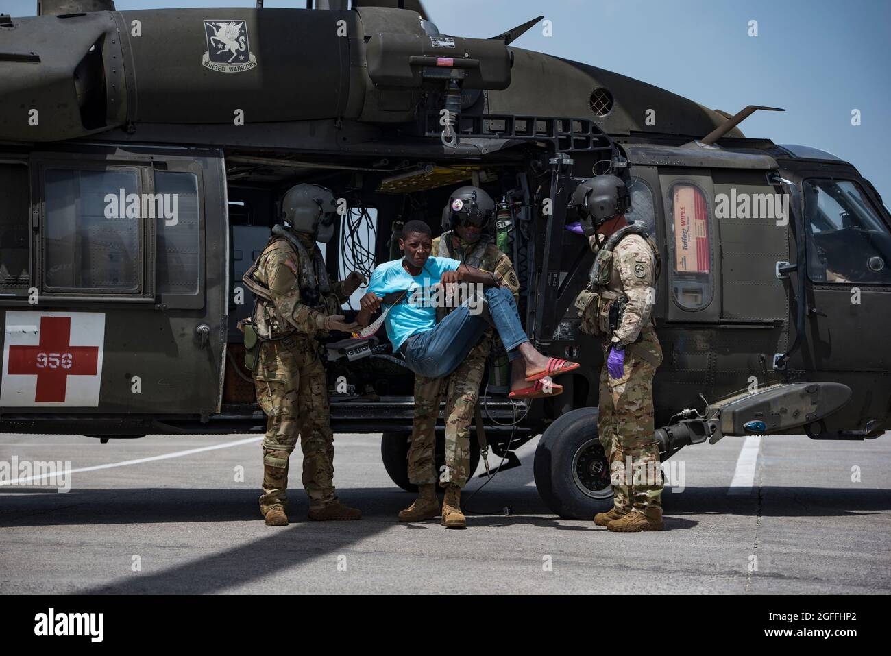 Port Au Prince, Haiti. 24th Aug, 2021. U.S. Army soldiers, with the 228th Aviation Regiment, unload a patient from a UH-60 Black Hawk helicopter during a medical evacuation mission August 24, 2021 in Port-au-Prince, Haiti. The military is assisting in the aftermath of the recent earthquake. Credit: Planetpix/Alamy Live News Stock Photo