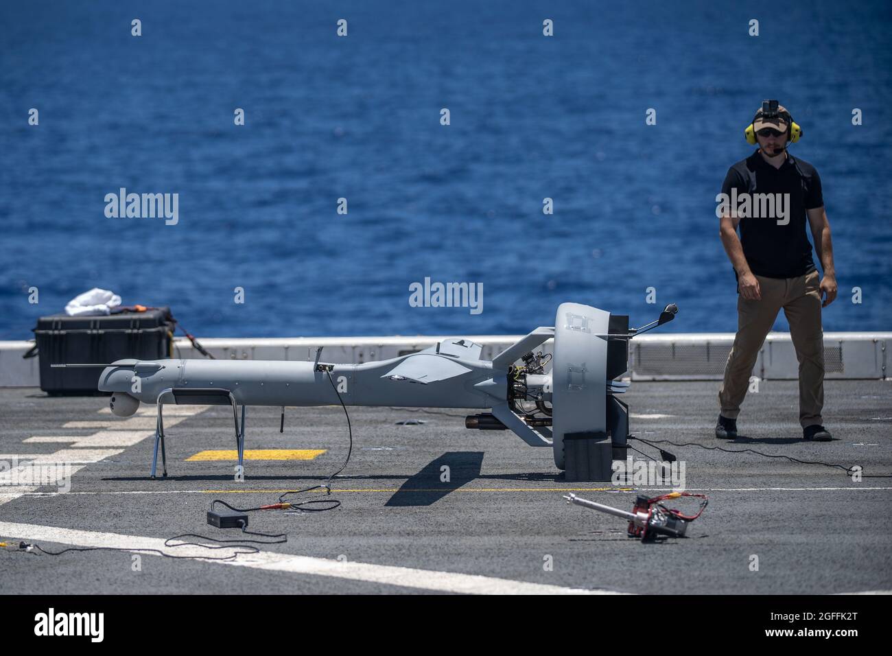 The U.S. Navy unmanned aerial vehicle operator, inspects a VBAT Unmanned Aerial System during pre-flight checks aboard amphibious transport dock USS Portland August 17, 2021 in the Pacific Ocean. Stock Photo