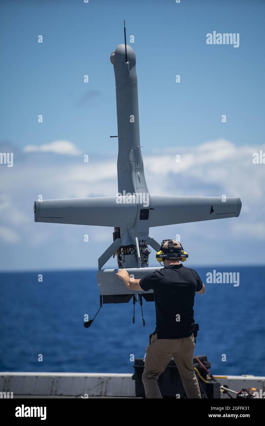 The U.S. Navy VBAT Unmanned Aerial Drone System is stabilized by an operator as it performs a vertical lift off from the flight deck of the amphibious transport dock USS Portland August 17, 2021 in the Pacific Ocean. Stock Photo