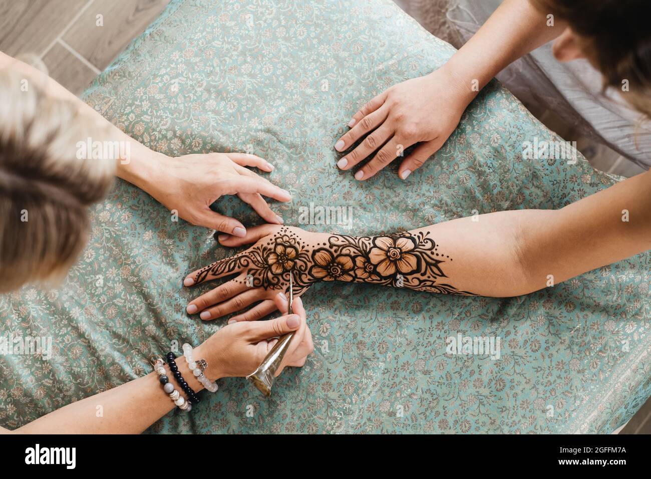 Artist Applying Henna Tattoo On Women Hands Mehndi Is Traditional Indian Decorative Art Hand With Floral Mehendi Beauty Drawing For Weddings And Stock Photo Alamy