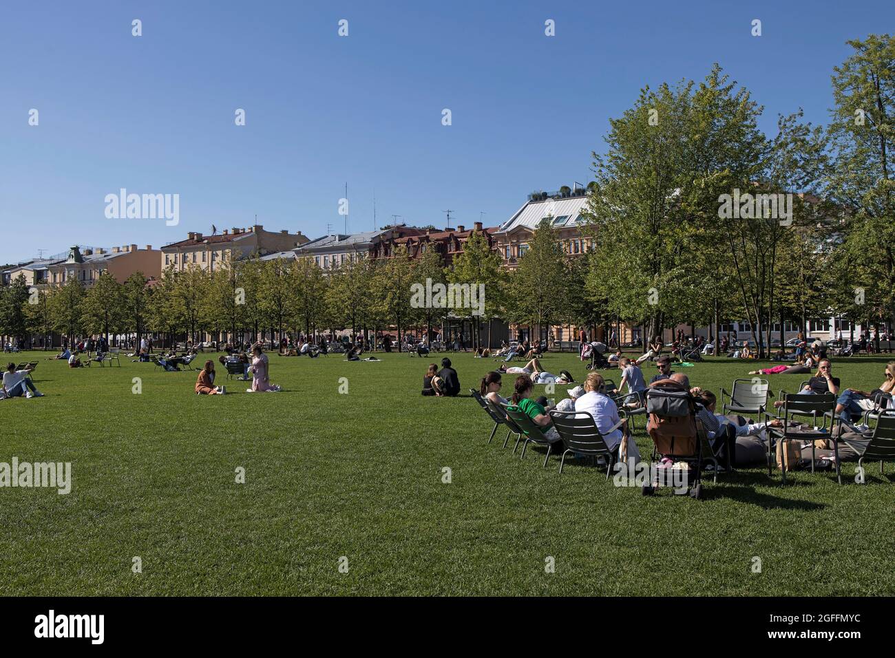 July 27, 2021 - St. Petersburg, Russia: People relaxing in the New Holland island of the city, modern hipster place to spend weekend. Green lawn is fu Stock Photo