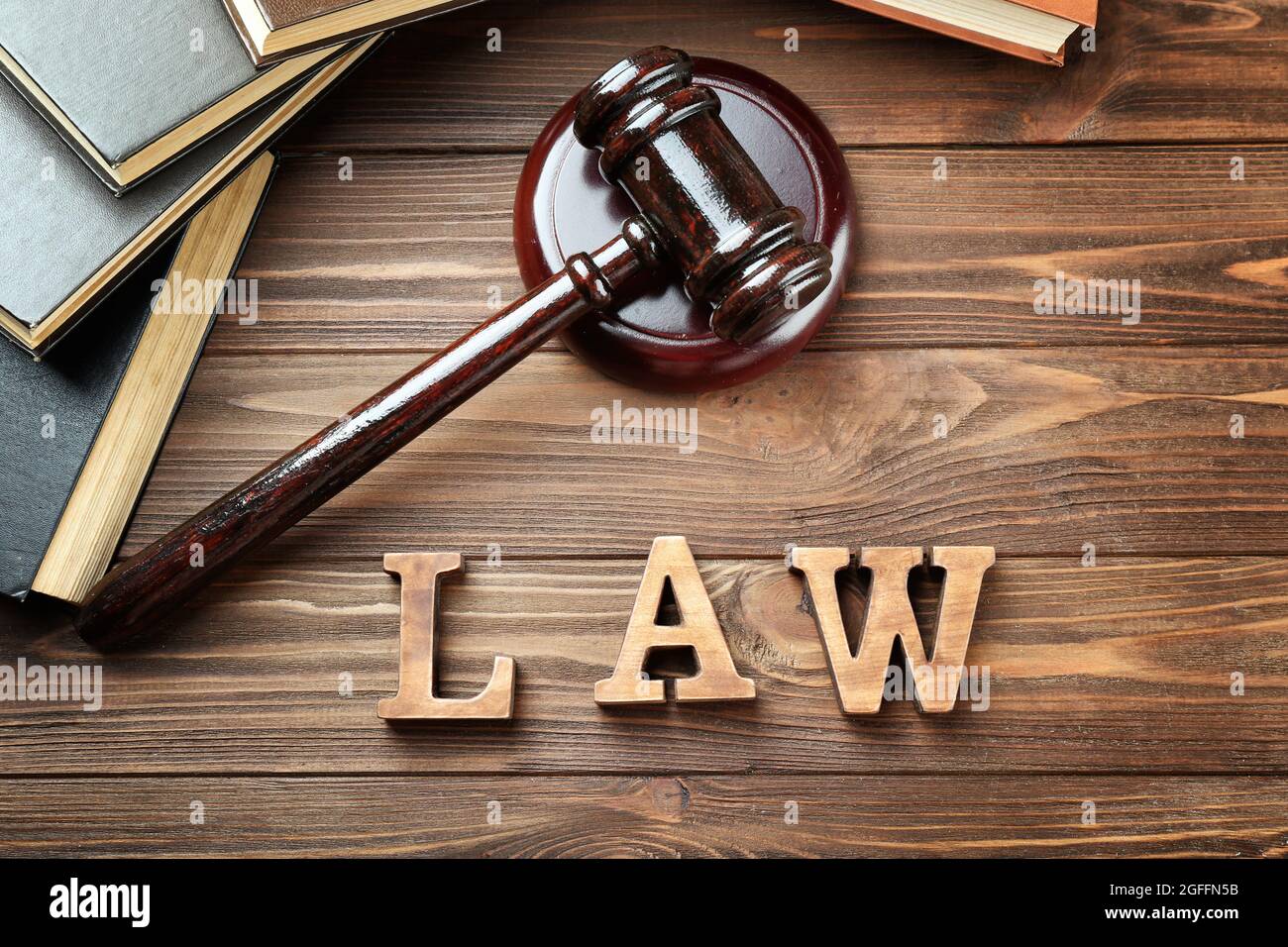 Word law with judges gavel and legal books on wooden background Stock