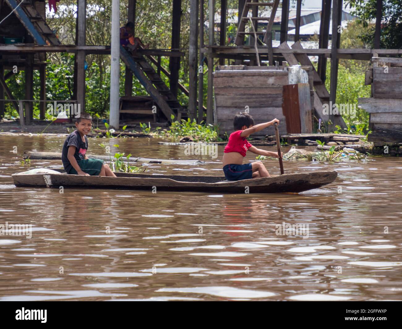 Belen, Peru- Dec 2019:Children on the boat between floating houses in the floodplain of the Itaya River, poorest part of Iquitos - Belén. Venice of La Stock Photo