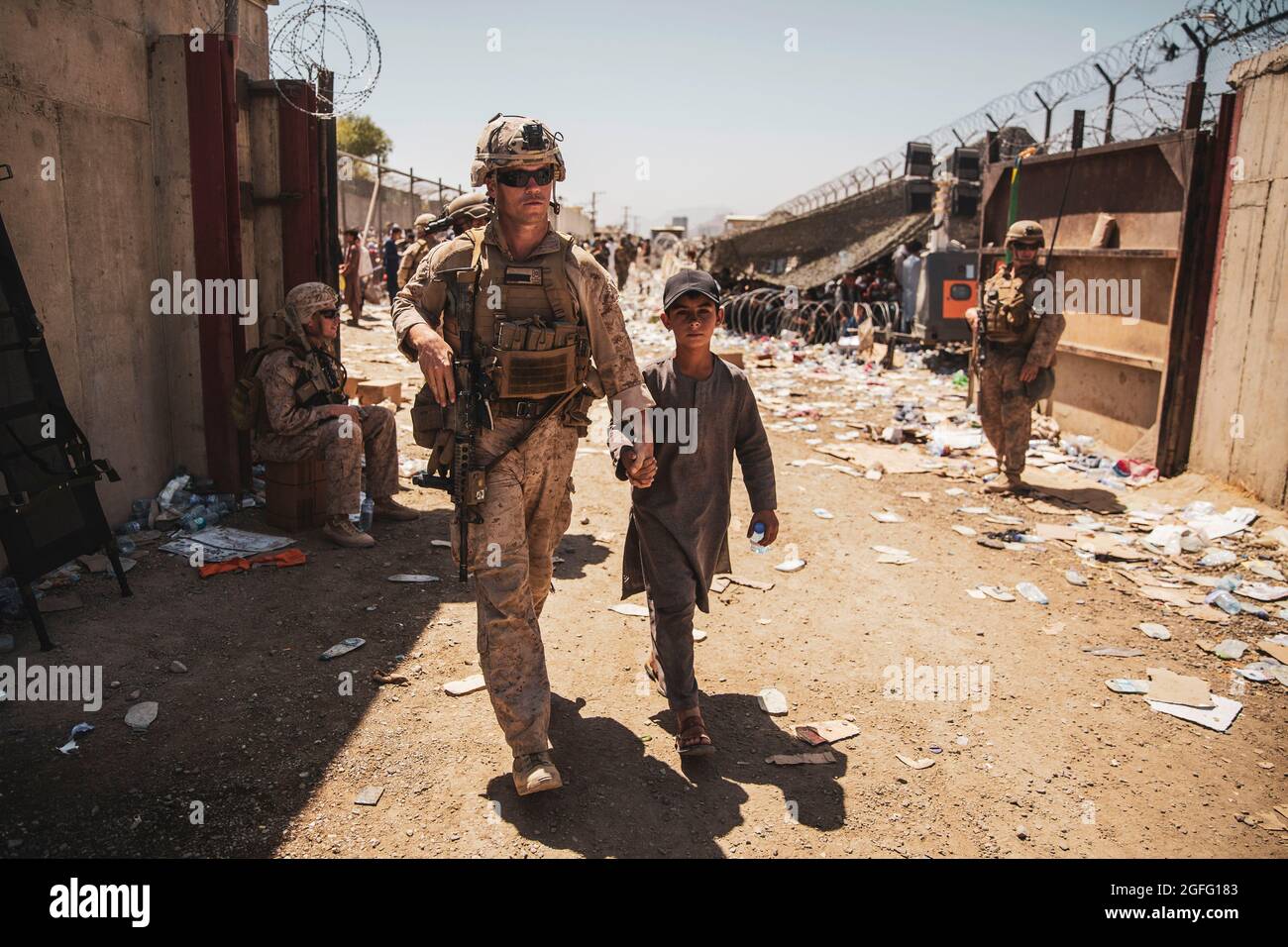 A United States Marine with the Special Purpose Marine Air-Ground Task Force-Crisis Response-Central Command (SPMAGTF-CR-CC) escorts a kid to his family during an evacuation at Hamid Karzai International Airport, Kabul, Afghanistan, August 24, 2021. US service members and coalition forces are assisting the Department of State with a non-combatant evacuation operation (NEO) in Afghanistan. Mandatory Credit: Victor Mancilla/US Marine Corps via CNP /MediaPunch Stock Photo