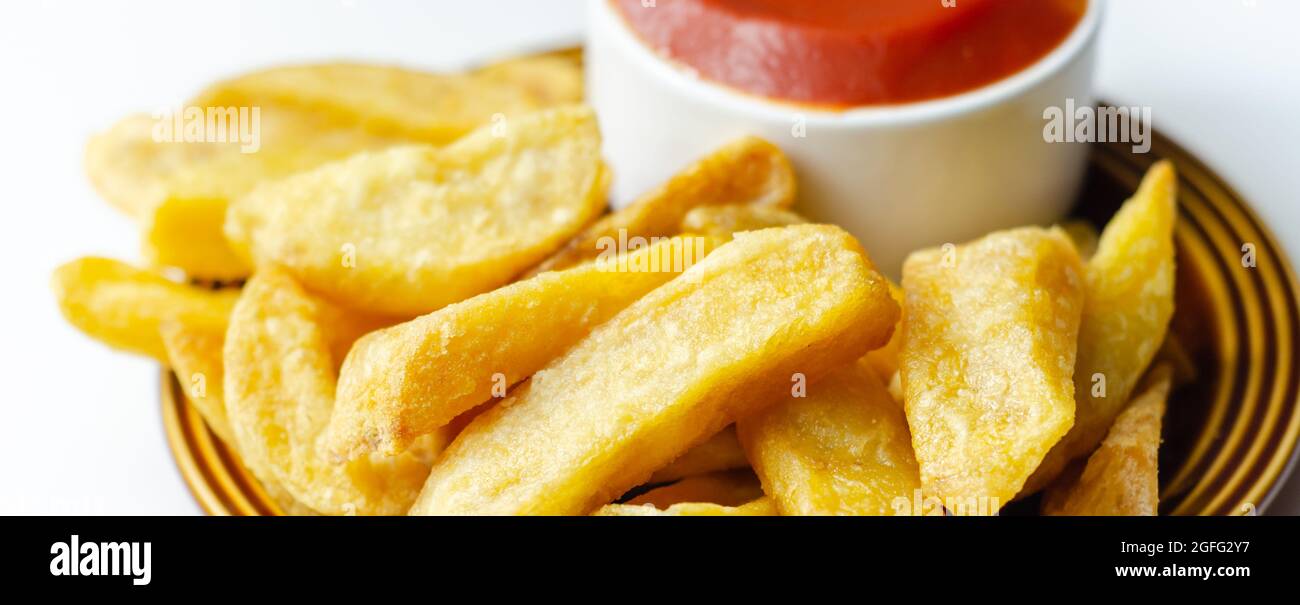 Deep fried and crispy delicious fries on the ceramic plate with tomato ...