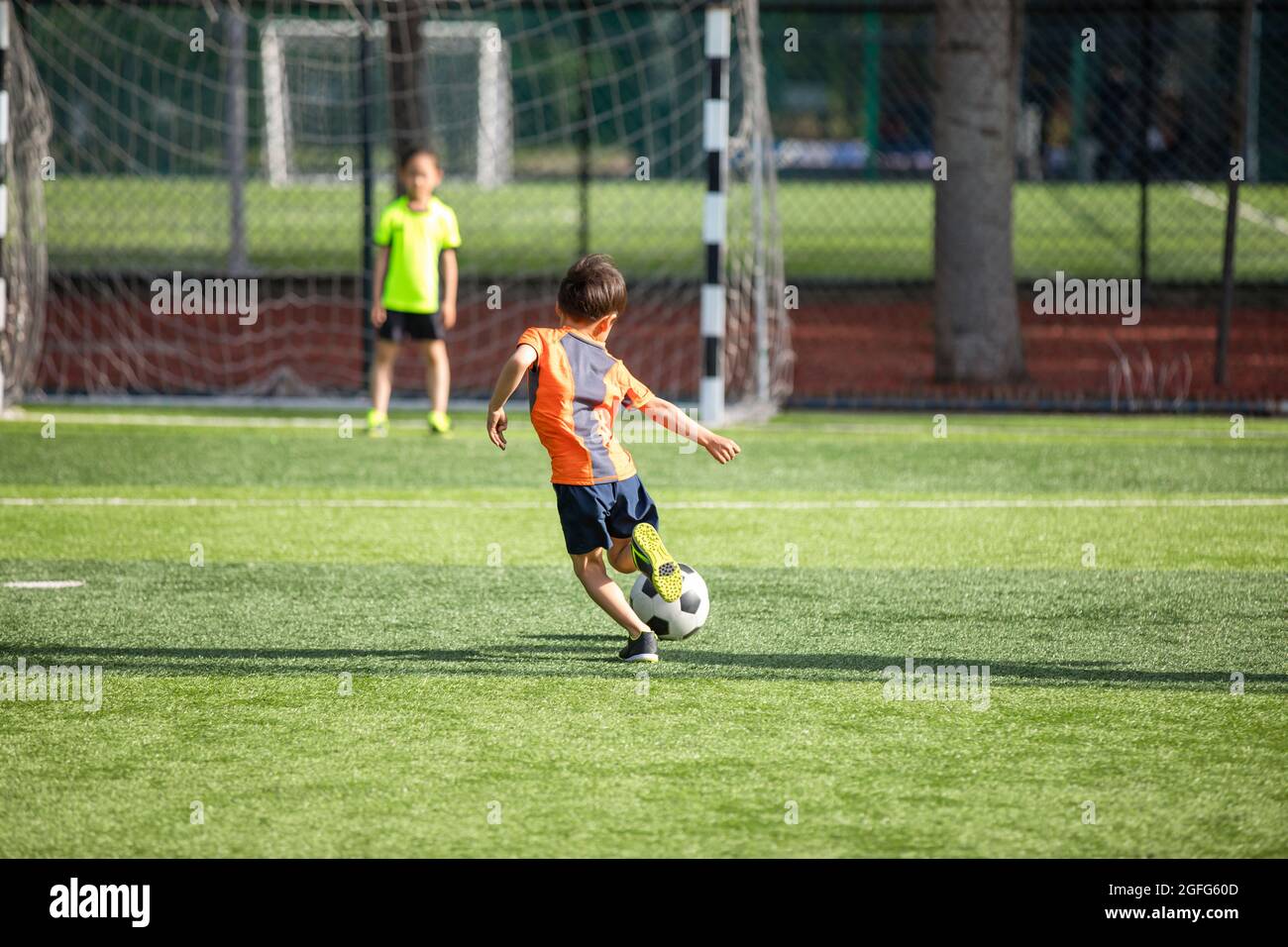 Children playing football on field Stock Photo - Alamy