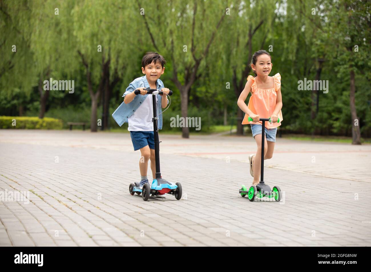 Kids Using Scooters Child playing in road with scooter hi-res stock photography and images ...