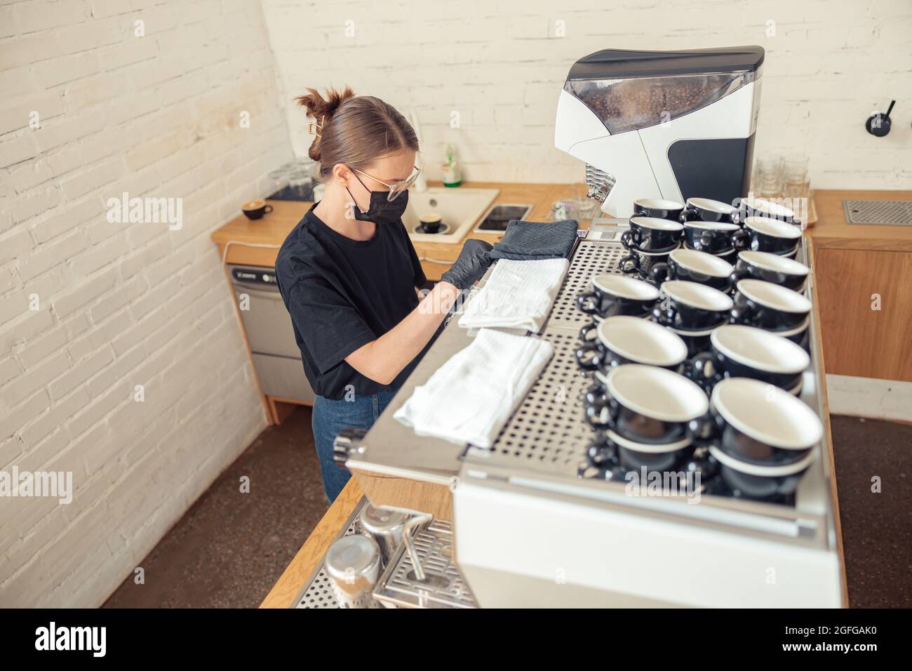 Barista in apron and black shirt making drink Stock Photo