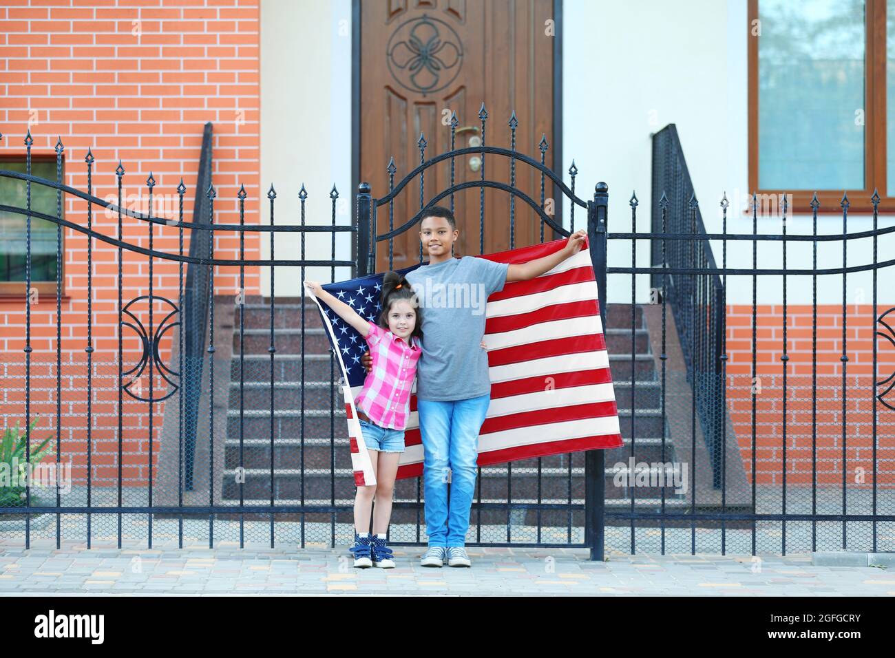 Boy and small girl with American flag on street Stock Photo - Alamy