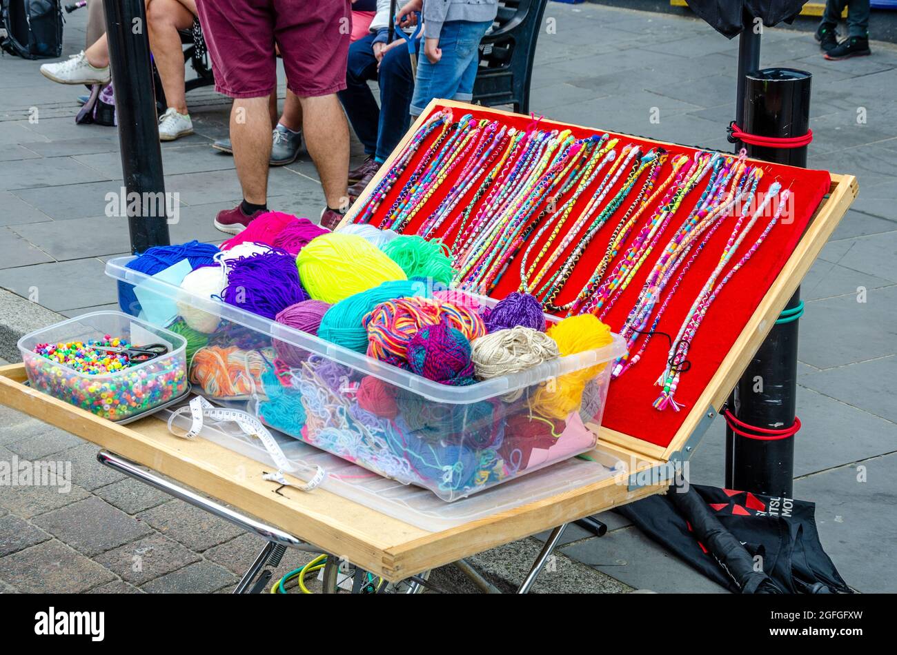 Balls of wool, braids and beads used by a person braiding hair for tourists in the street in Tenby, Wales. Stock Photo