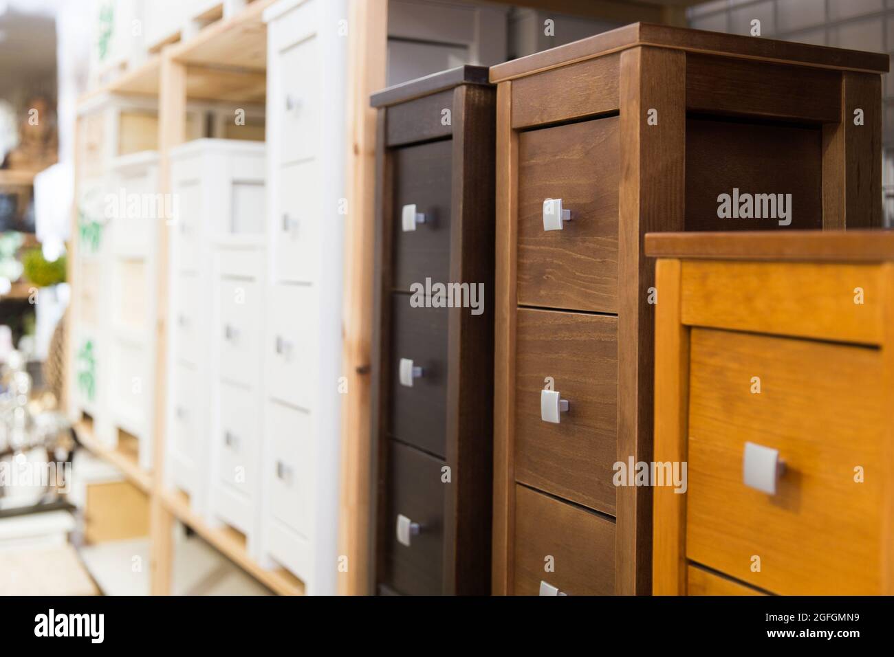 Wooden bedside tables with drawers on shelves of furniture store Stock