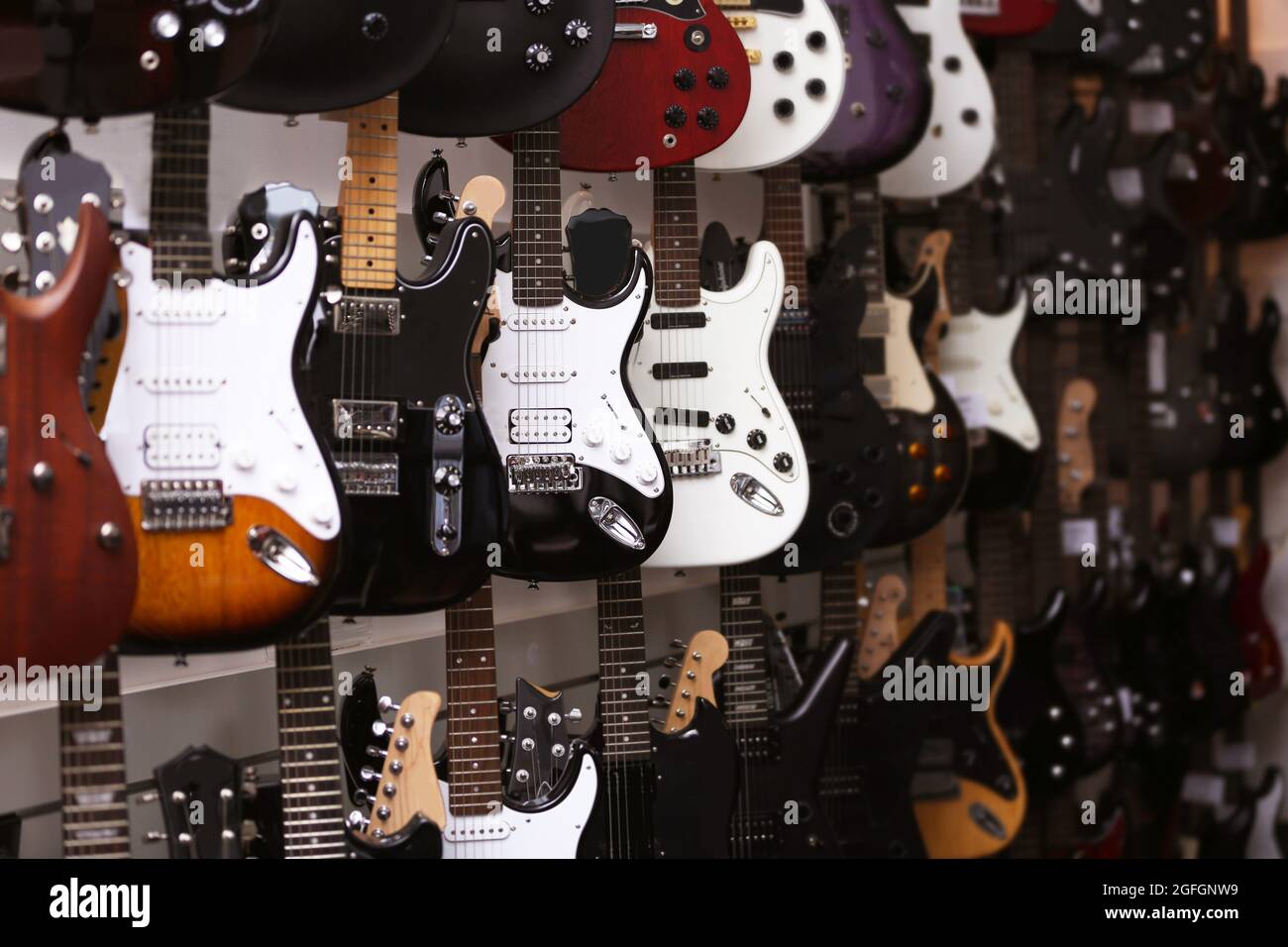 Guitars hanging on wall, closeup Stock Photo Alamy