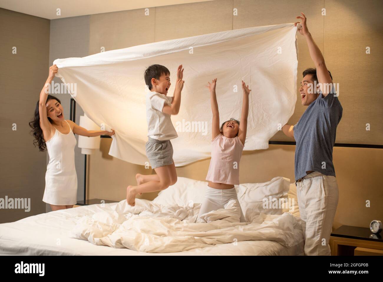 Happy young family having fun in bedroom Stock Photo - Alamy