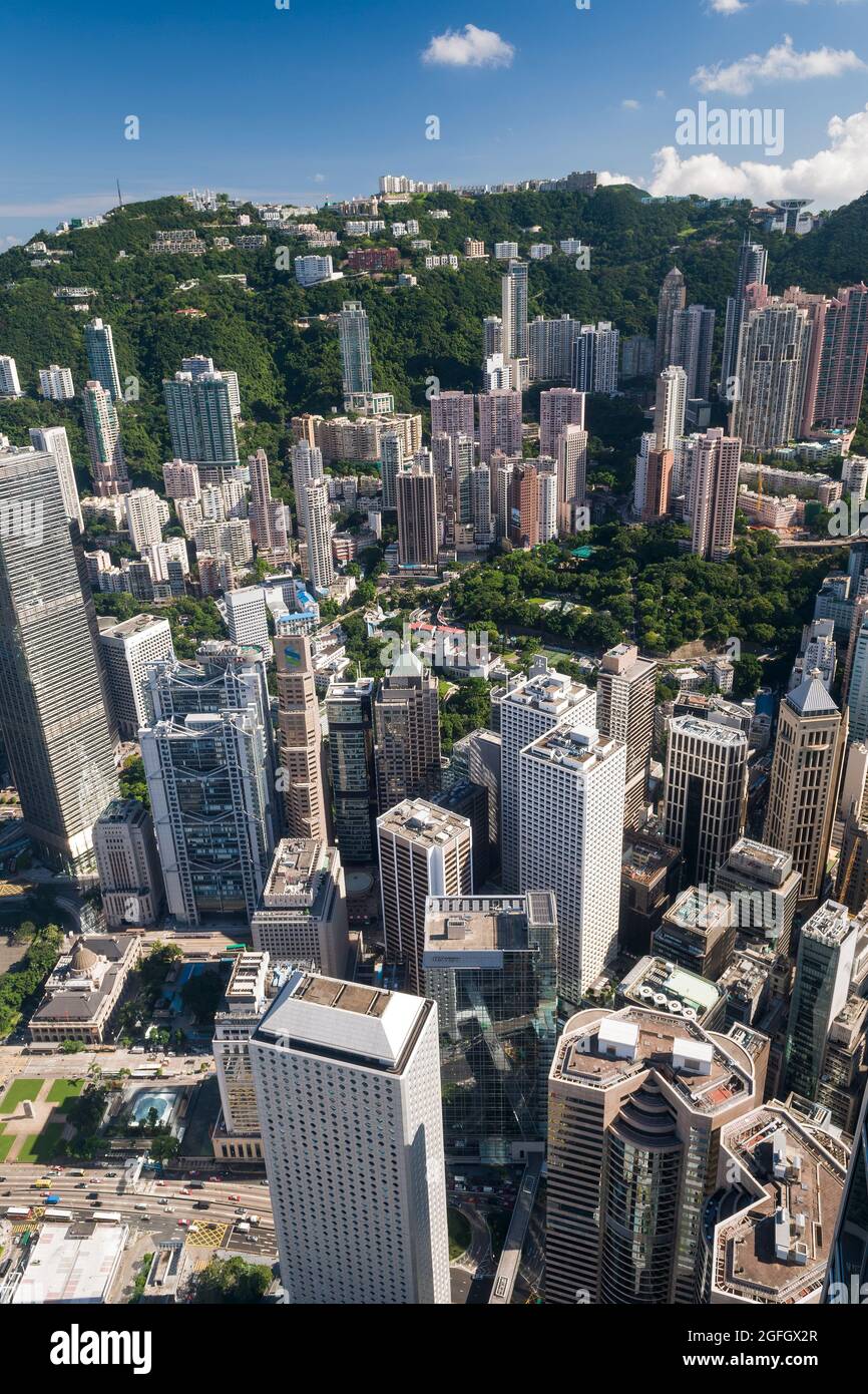 The high-rise residential apartment blocks of Mid-levels and luxury houses on The Peak behind the commercial buildings of Central, Hong Kong Island Stock Photo