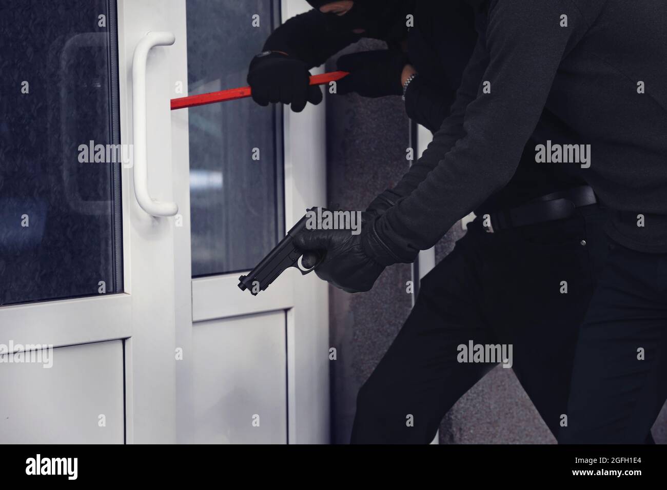 Armed thieves breaking a door Stock Photo