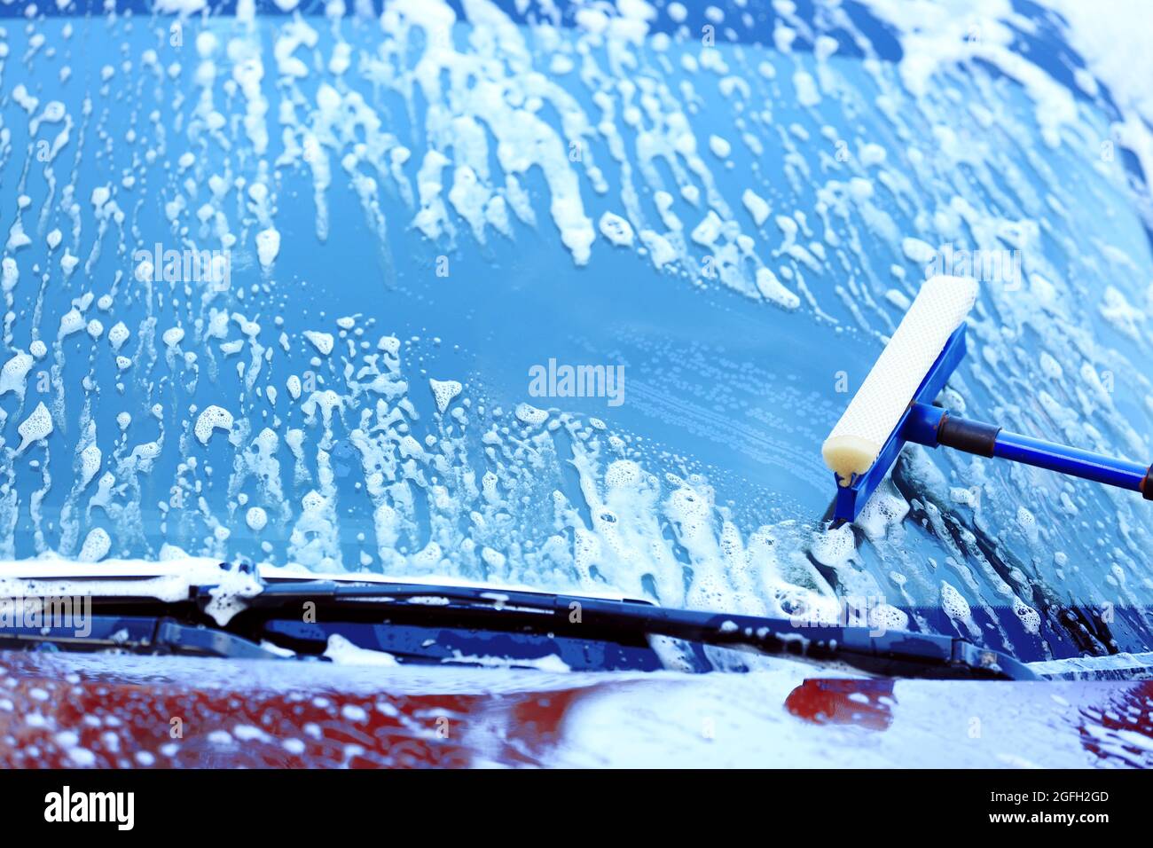 Washing windscreen with window cleaner Stock Photo Alamy