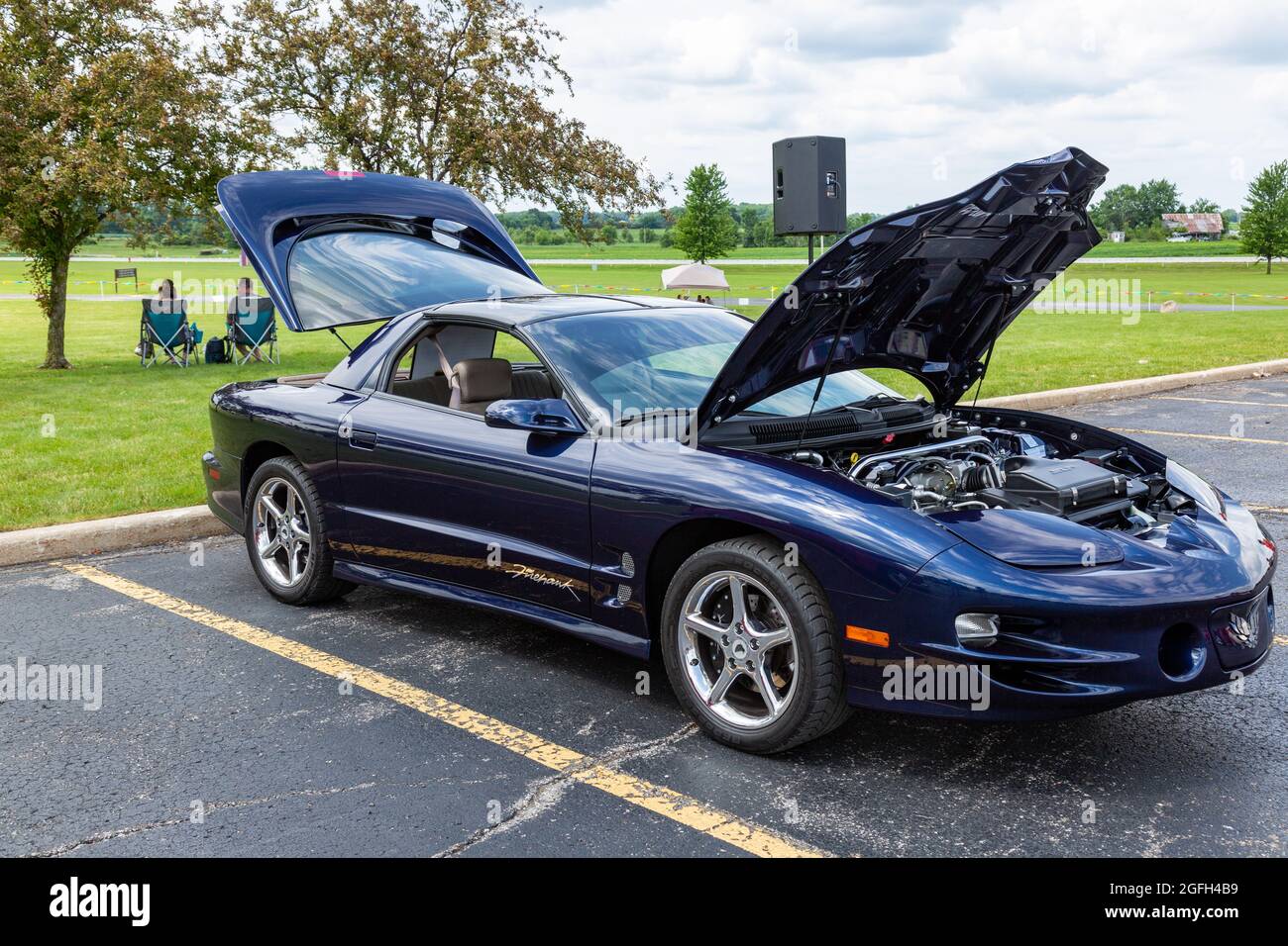 A dark blue 2000 Pontiac Firebird Trans Am Firehawk coupe on display with the hood and rear hatch open at a car show in Angola, Indiana, USA. Stock Photo