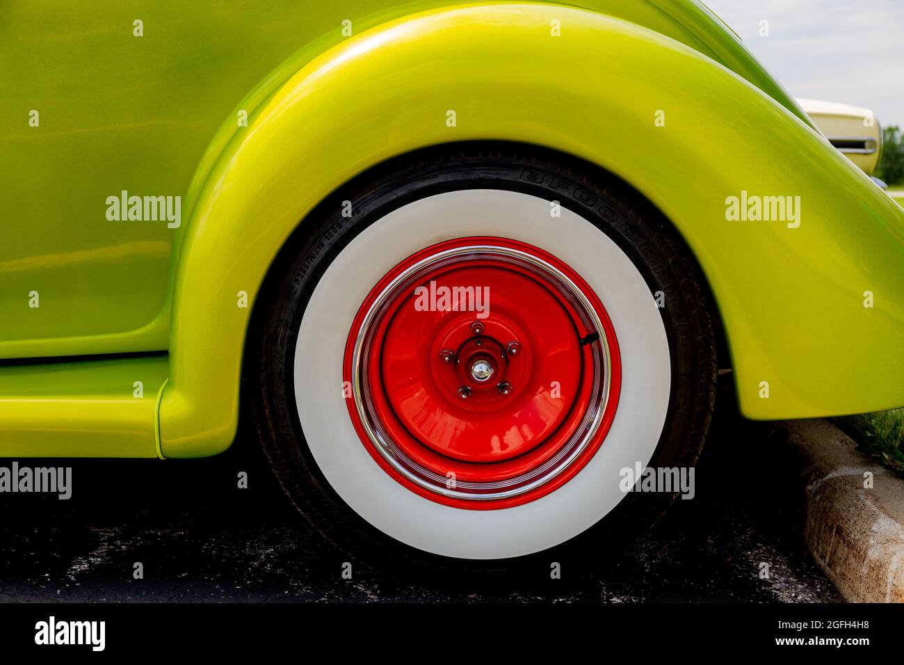 The orange steel wheel contrasts nicely with the chartreuse paint on this customized antique 1936 Ford. Stock Photo
