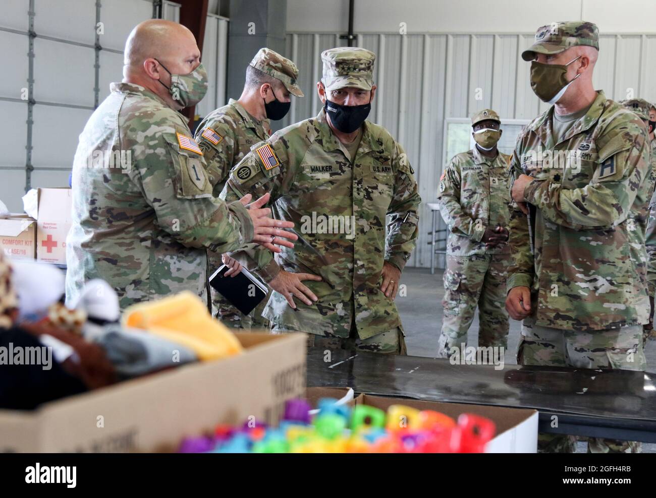 U.S. Army Lt. Gen. Donnie Walker, center, deputy commanding general of U.S. Army Materiel Command and the senior commander at Redstone Arsenal, Alabama, listens as Sgt. 1st Class Gordon Bruenning, left, assigned to 1st Battalion, 337th Brigade Support Battalion, Task Force McCoy, talks about the support his unit is providing to Afghans while they stay at Fort McCoy, Wisconsin, Aug. 23, 2021. The Department of Defense, in support of the Department of State, is providing transportation and temporary housing in support of Operation Allies Refuge. This initiative follows through on America's commi Stock Photo