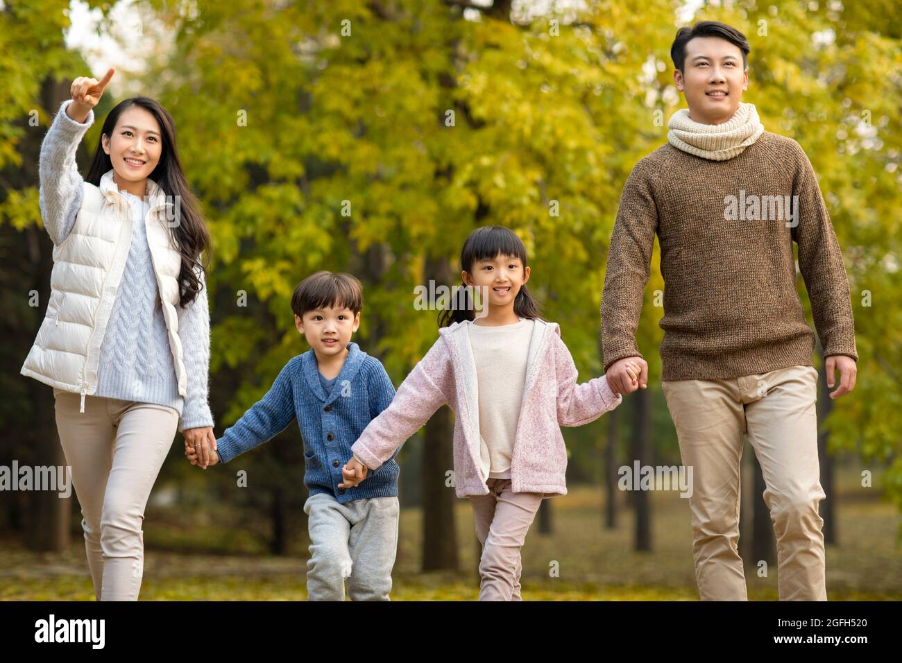 Happy young family having fun in woods Stock Photo