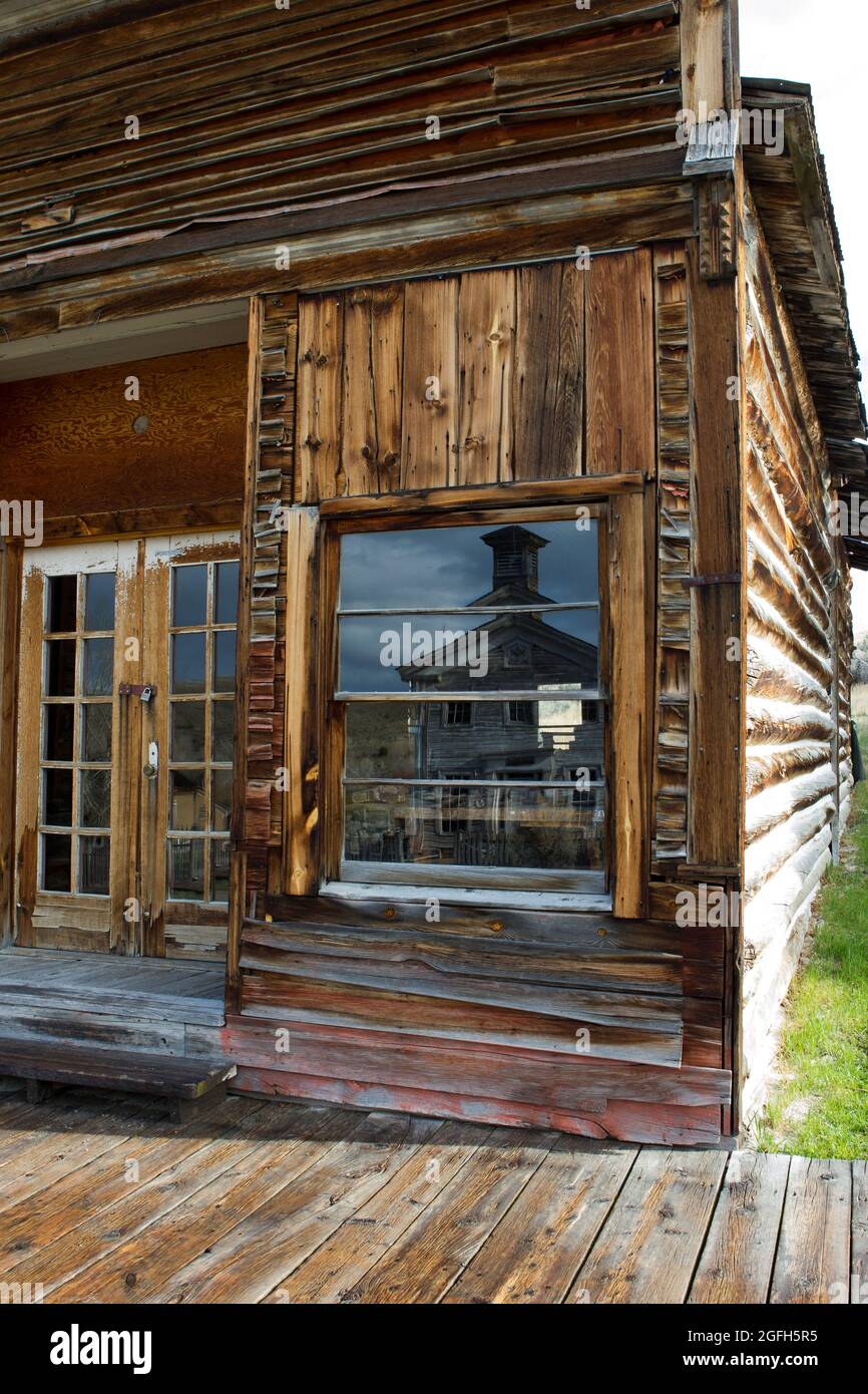 Reflection of the Schoolhouse/Masonic Temple in window of building (just east of Assay Office), Bannack State Park, MT. Stock Photo