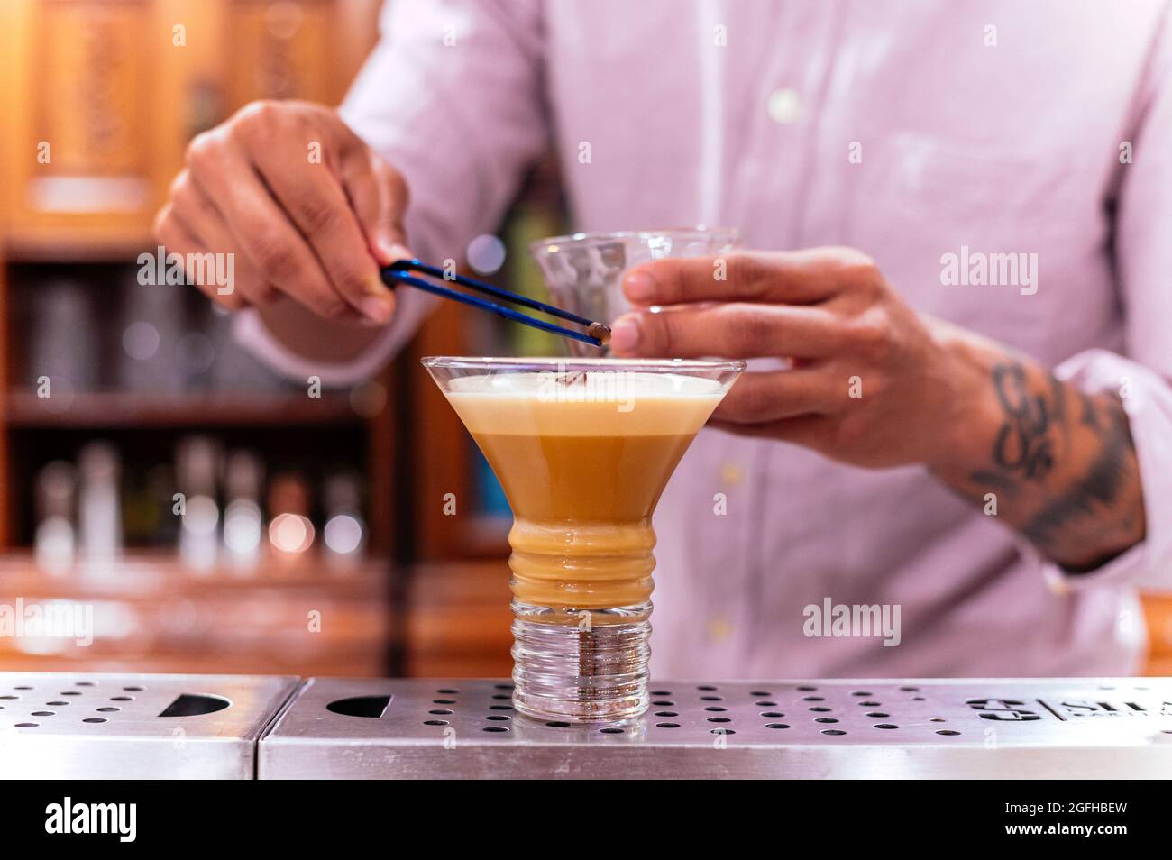 Barman decorating alcoholic drink called irish coffee Stock Photo