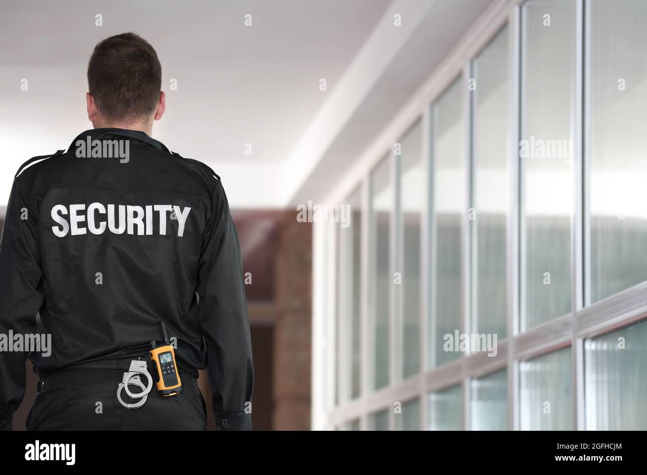 Security man standing back in corridor Stock Photo - Alamy