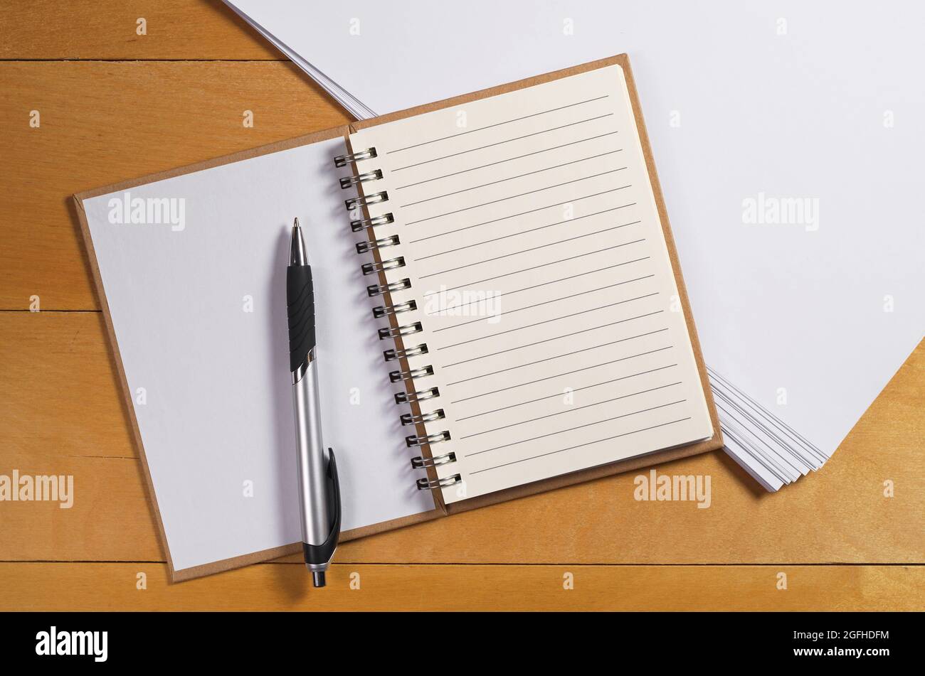 Notepad with a pen and clean sheets of white paper on yellow wooden ...