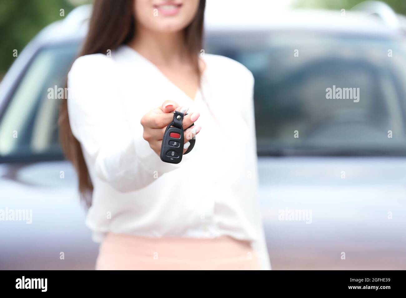 Young woman using car alarm key on car blurred background Stock Photo ...