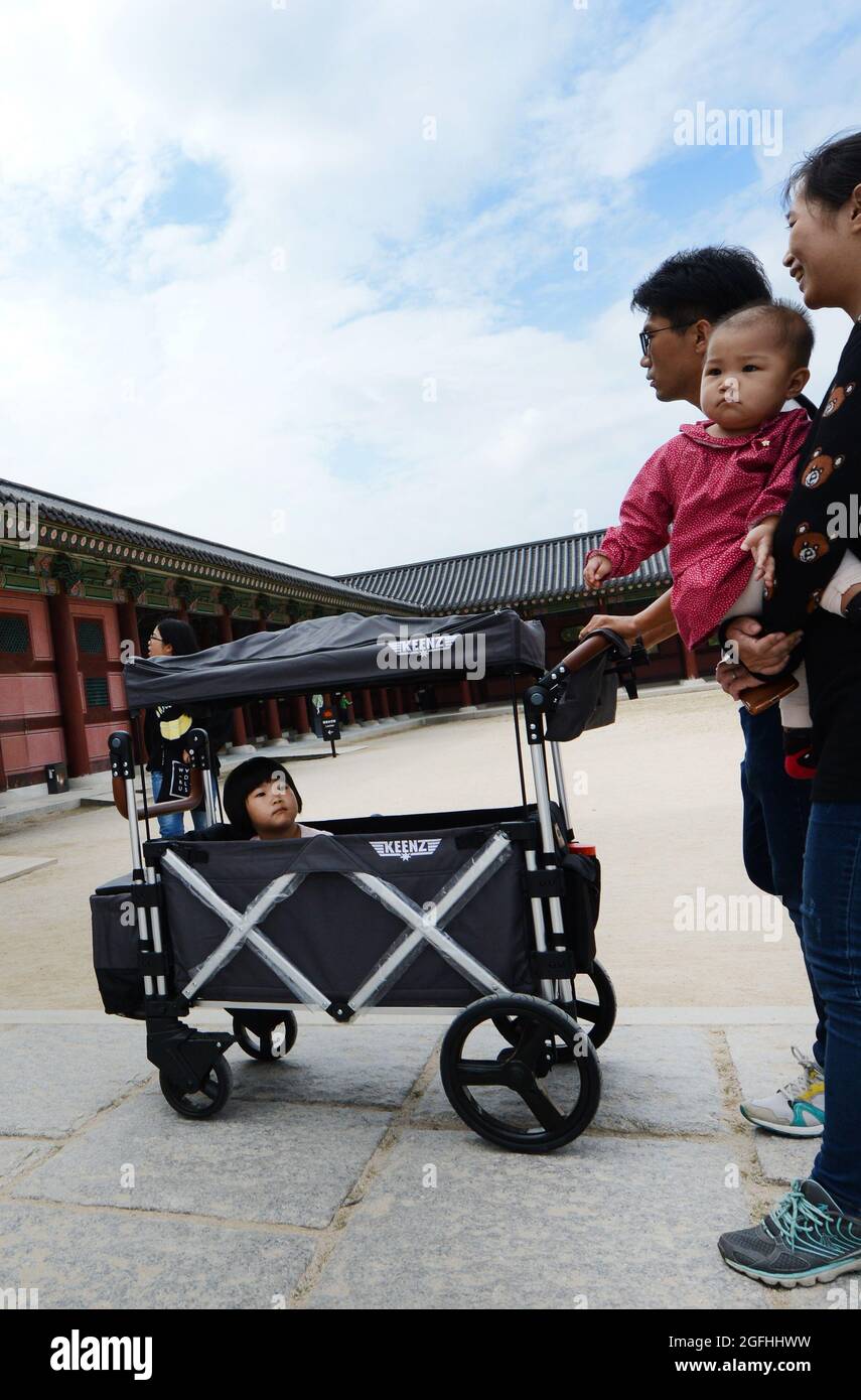 Carrying their toddler in a cool trolley at the Gyeongbokgung palace in