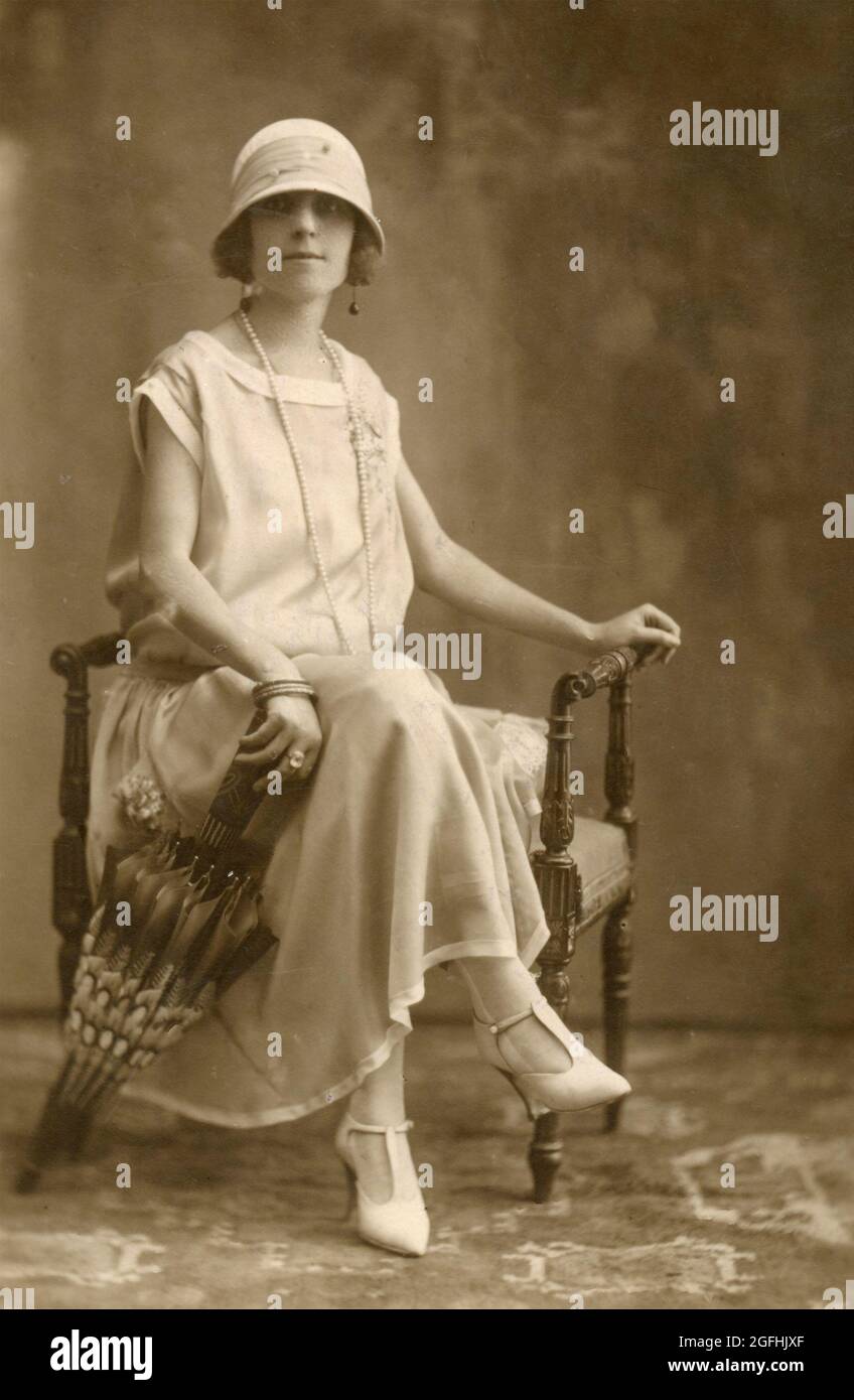 Woman wearing hat and long white dress 
