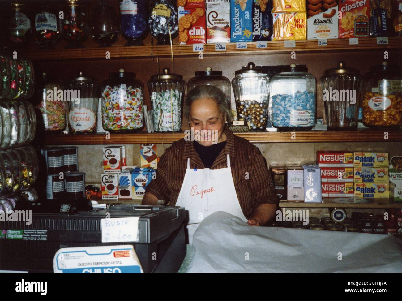 Old woman at the cashier of the candy shop in Trastevere, Rome, Italy