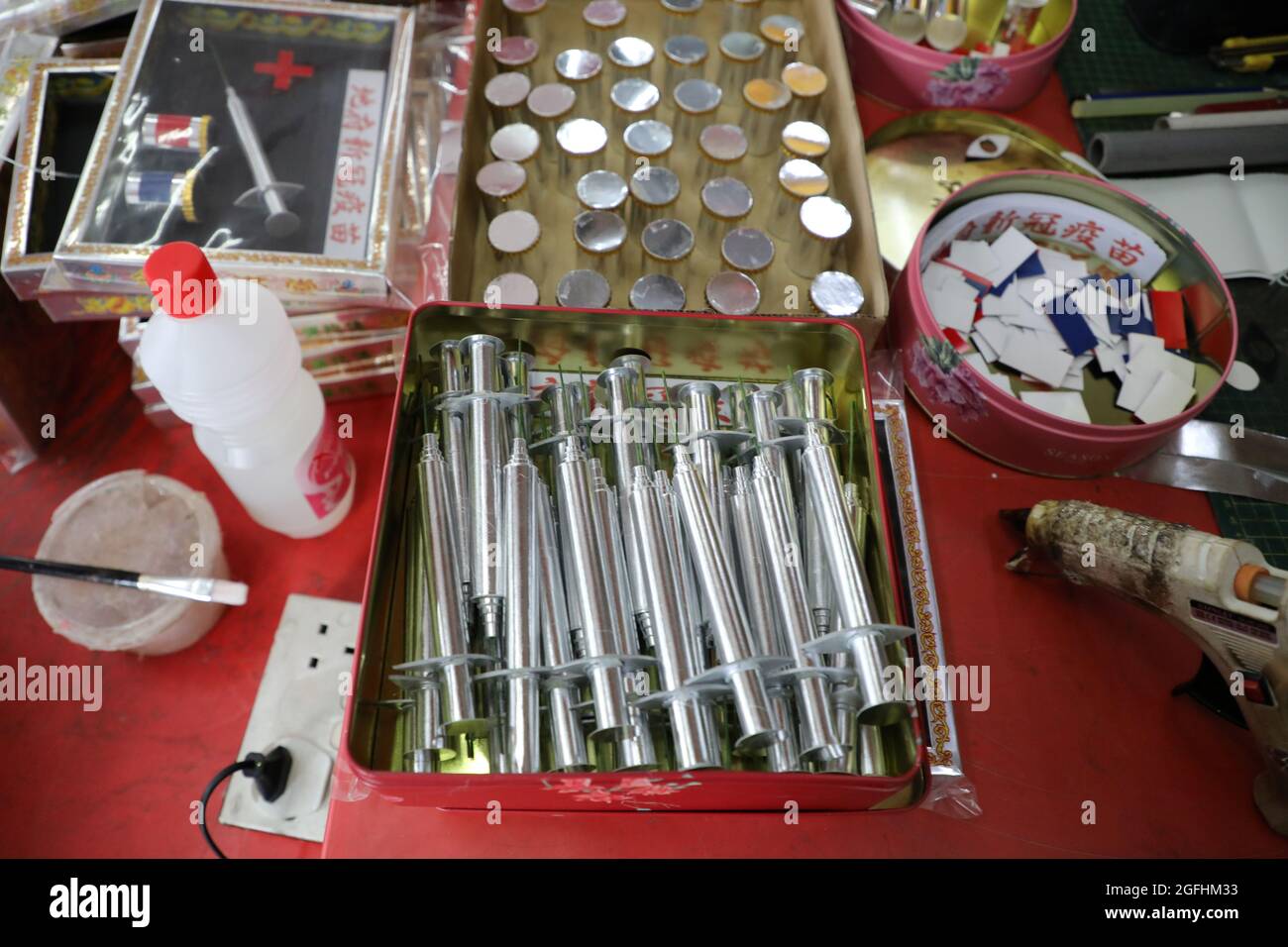 Paper syringes and vaccine vials are pictured at a prayer paraphernalia