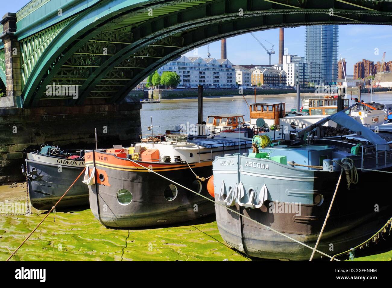 Colourful barges (now houseboats) under the arch of Battersea Railway