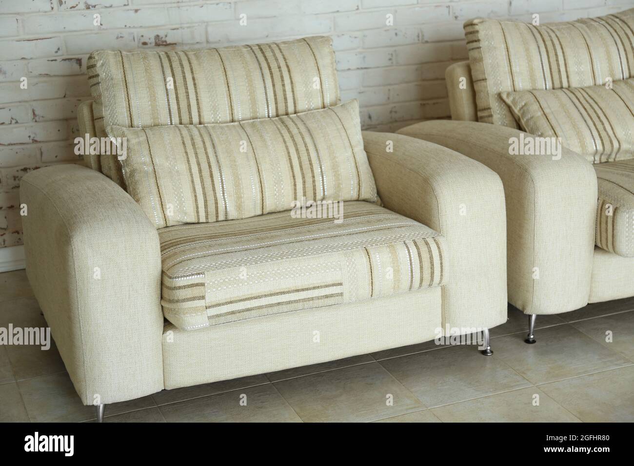 Modern armchair and sofa in room interior Stock Photo - Alamy