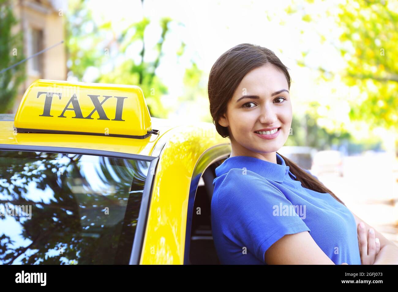 Beautiful female taxi driver standing near car Stock Photo - Alamy