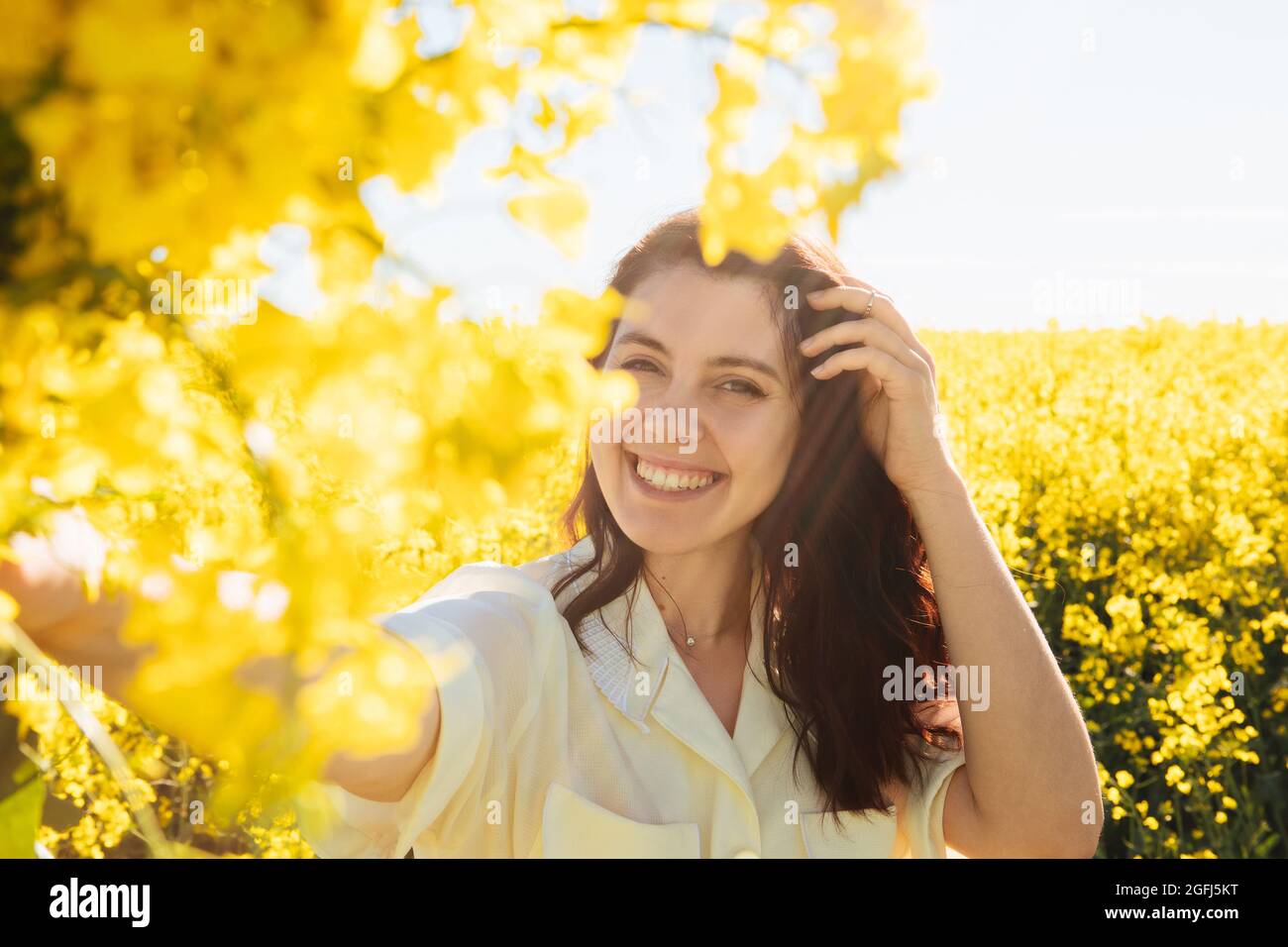 beautiful woman standing in rapeseed field summertime Stock Photo - Alamy