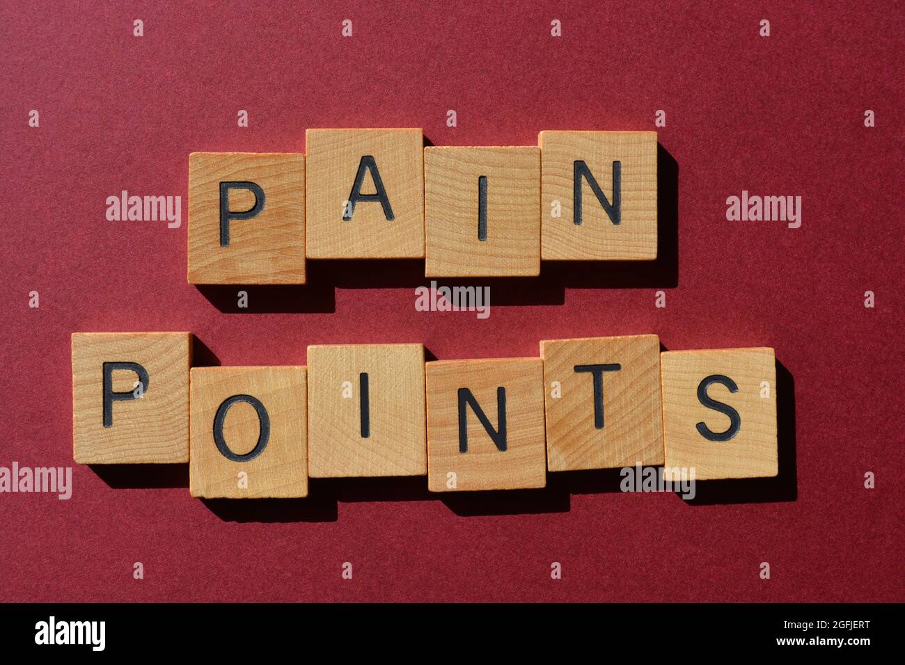Pain Points, words in wooden alphabet letters isolated on colour