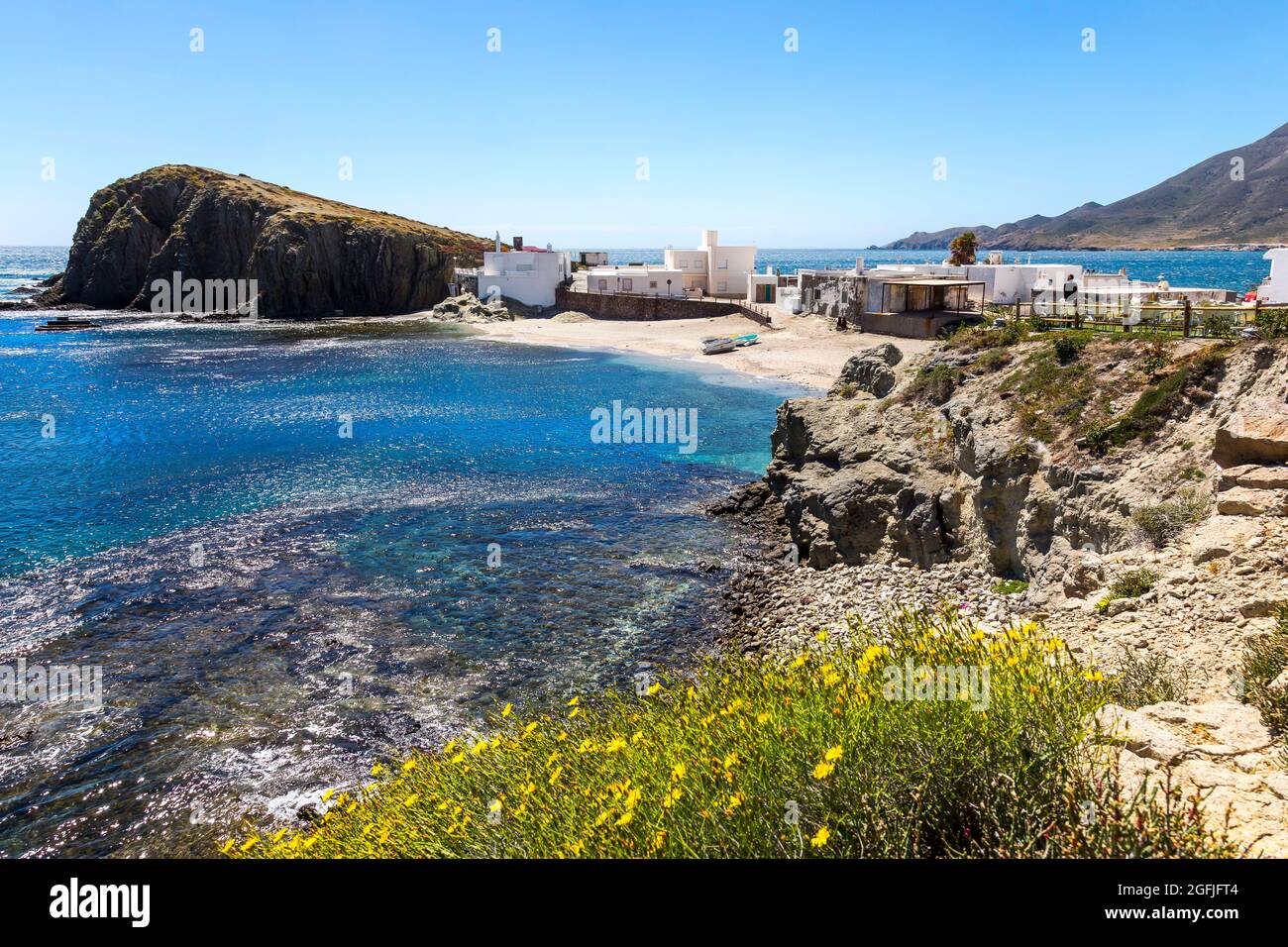 Landscape of the coastal area Cabo de Gata, province of Almeria, Andalucia, Spain. Landscape with rock and houses in the village of La Isleta del Moro Stock Photo