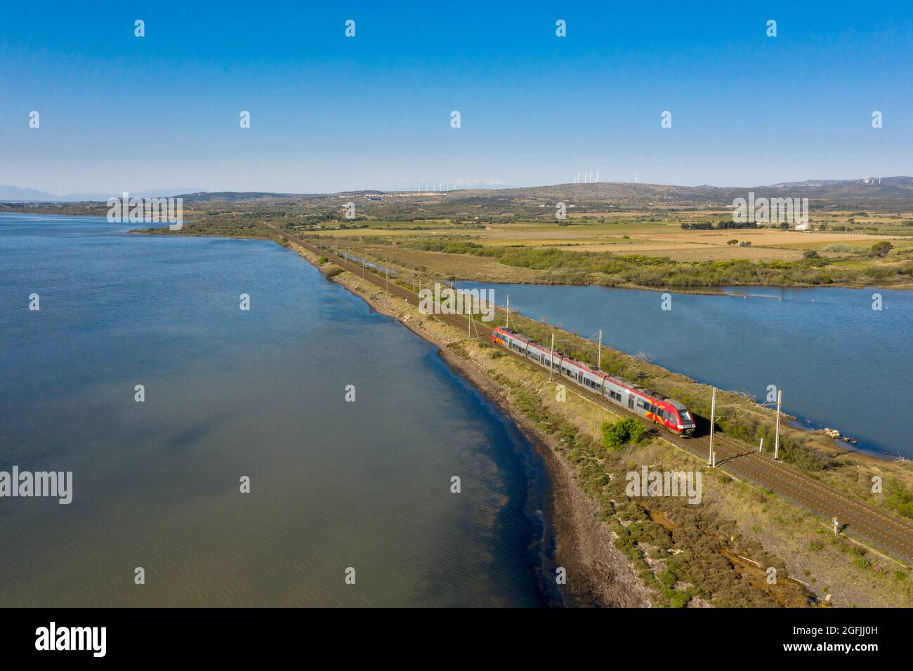 Railroad tracks over the pond of Salses Leucate, TER local train, Bombardier train belonging to the “Lio” network, between the stations of La Franqui Stock Photo