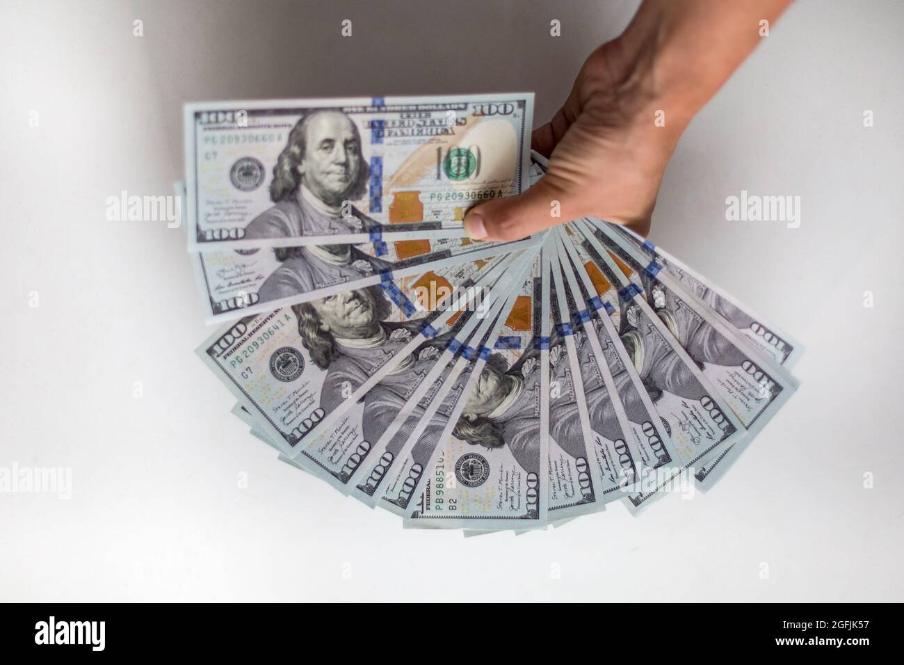 Male hand holds one hundred USD banknotes money: 100 dollars currency banknotes. Inflation, business, economics and finance theme. Stock Photo