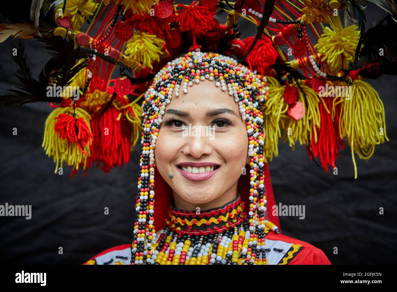 Young lady dressed in traditional Thailand rural village tribe costume and headdress in Manchester, England, UK Stock Photo